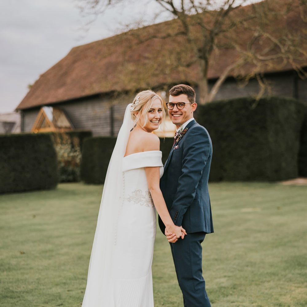 Bride & groom laugh outdoors during post wedding photoshoot