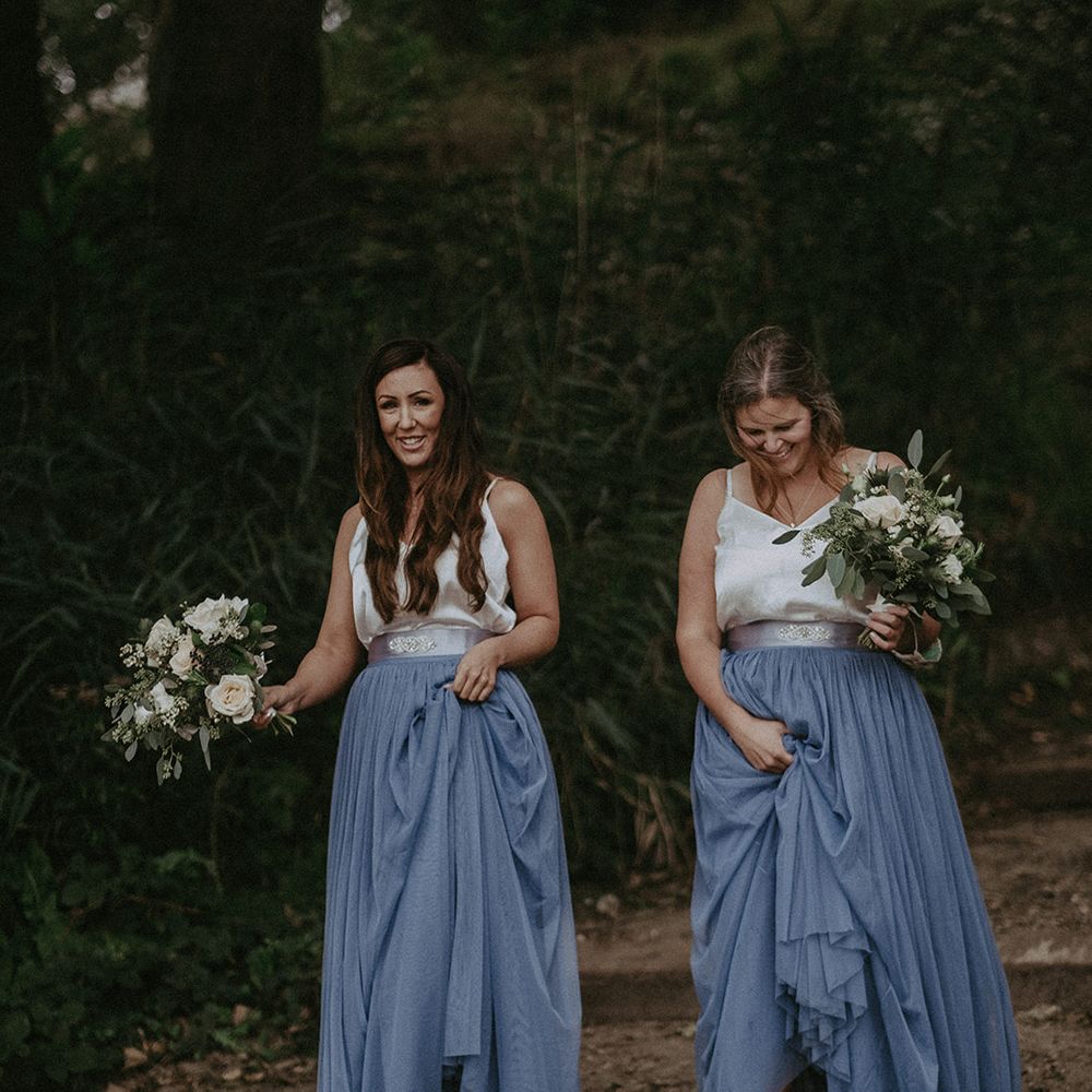 Bridesmaids wearing dresses with pale blue skirts and silver strappy tops