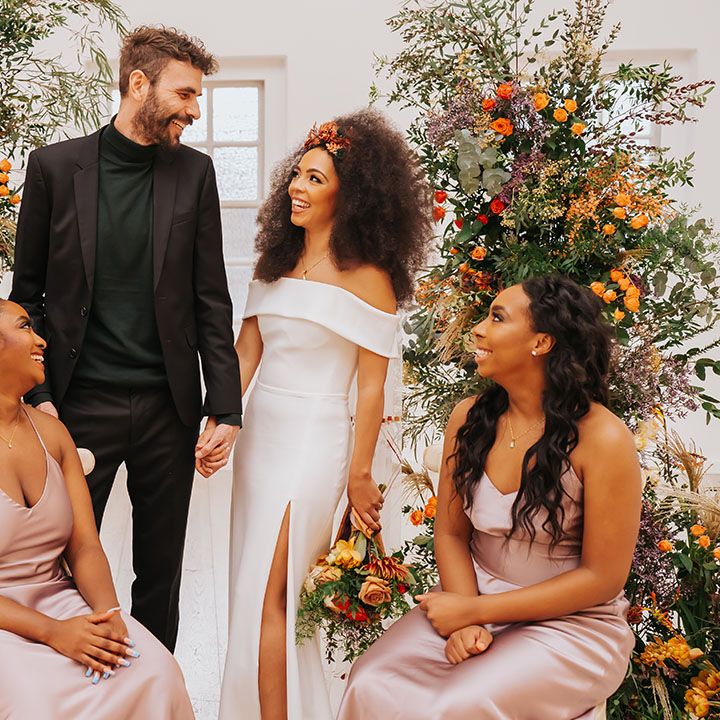 Minimalist wedding with column flowers, groom in all black, Black bride in an off the shoulder wedding dress and bridesmaids in rose satin bridesmaid dresses 