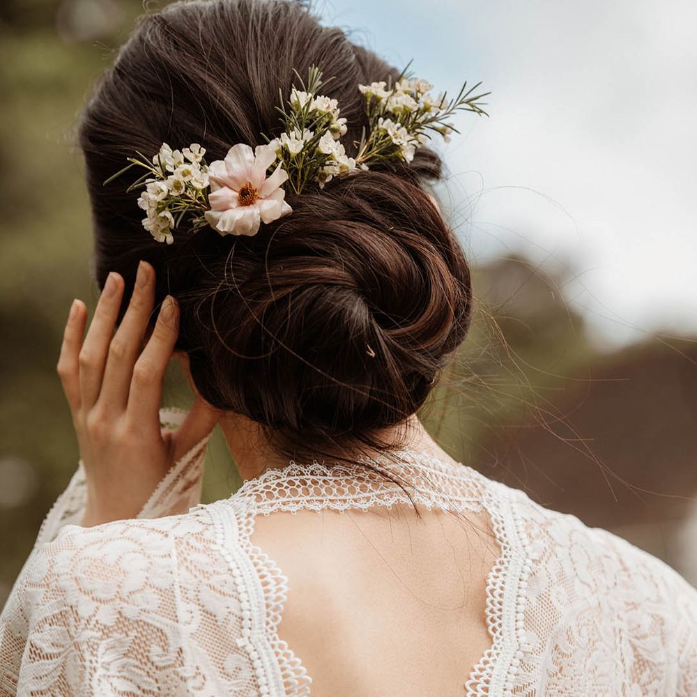 East Asian bride in a lace kimono style wedding dress with chic bridal up do decorated with fresh flowers 