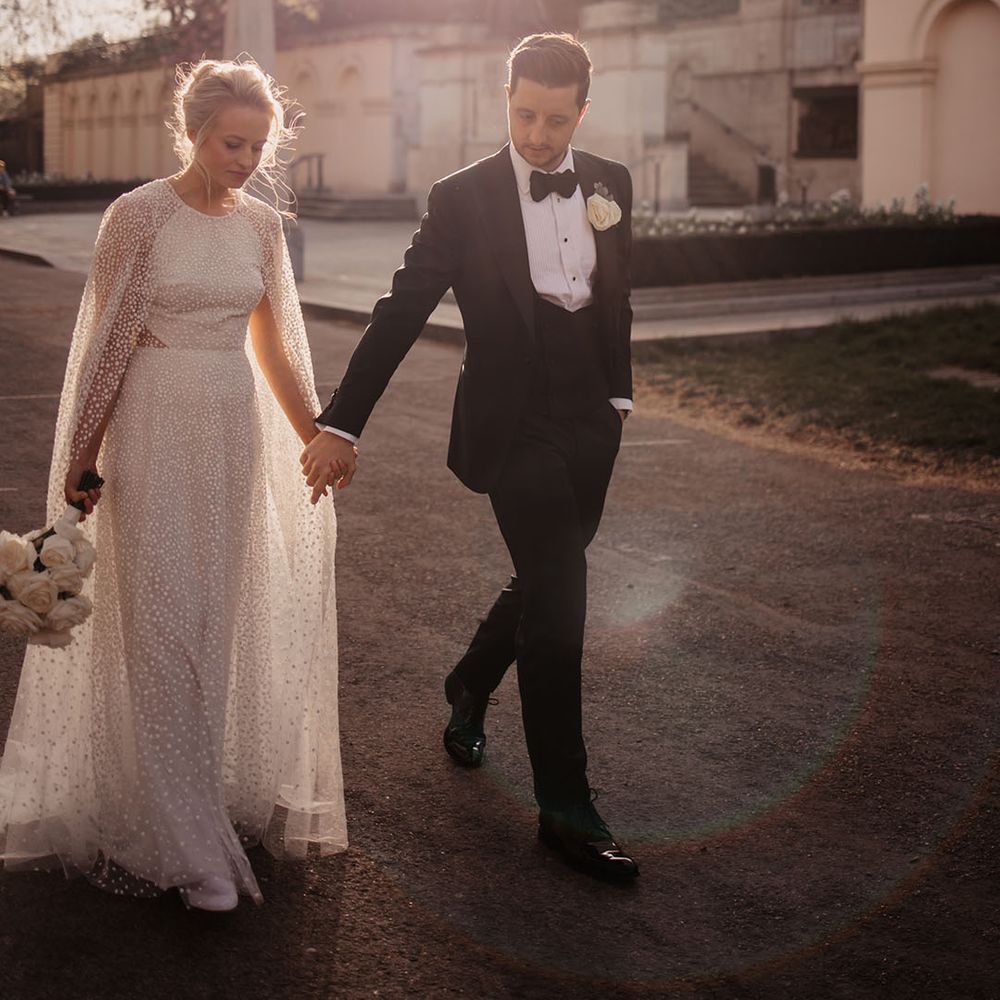 Bride and groom walk together during golden hour for their city wedding 