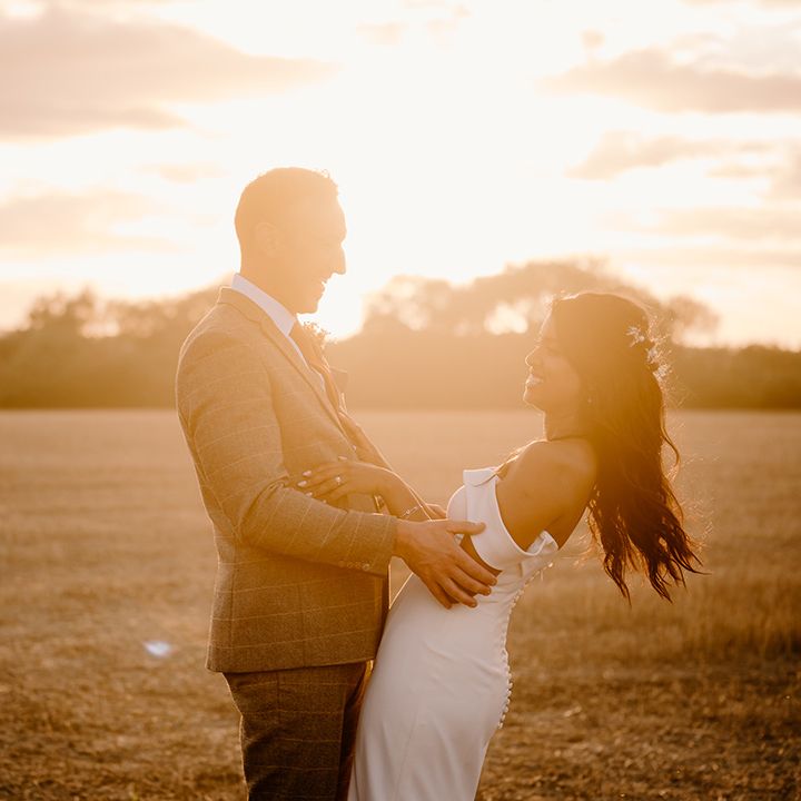 Golden hour wedding couple portrait of the bride and groom laughing together 