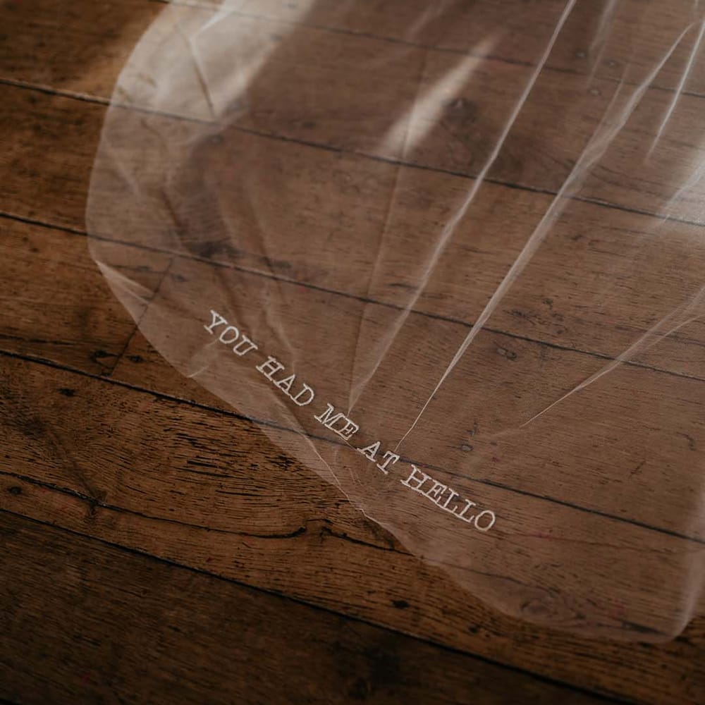 Sheer wedding veil with embroidered lettering saying "You had me at hello" at the base 