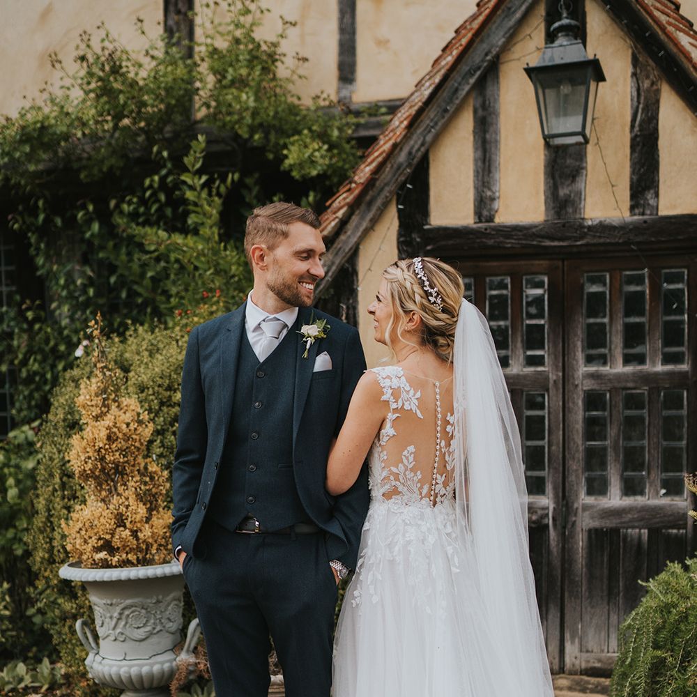 Bride in button back illusion Dando London wedding dress with the groom in dark blue suit at Dove Barn Weddings 