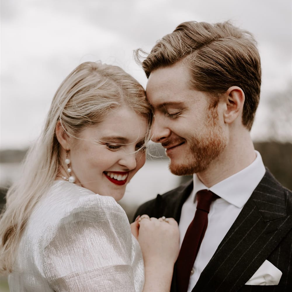 Groom in pinstriped suit with red tip for gothic Halloween wedding with the bride in a metallic wedding dress 