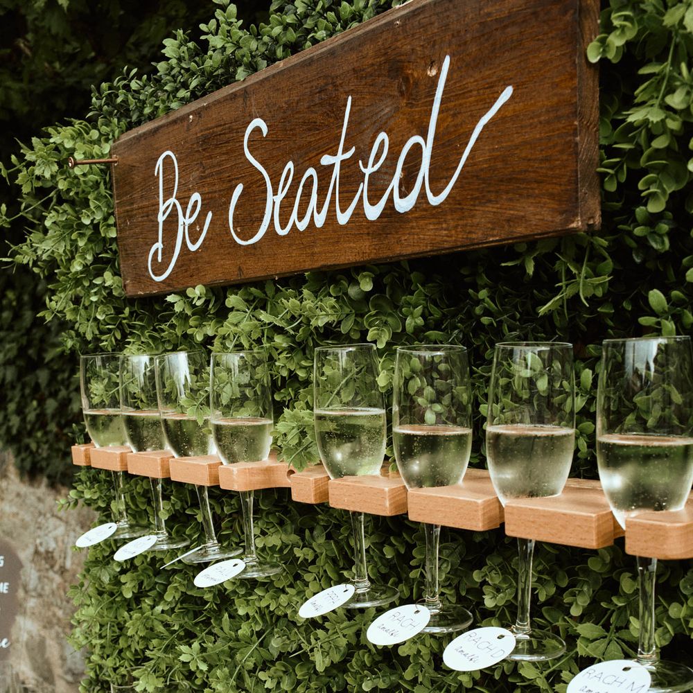 Wedding prosecco wall with greenery at destination wedding in Tuscany
