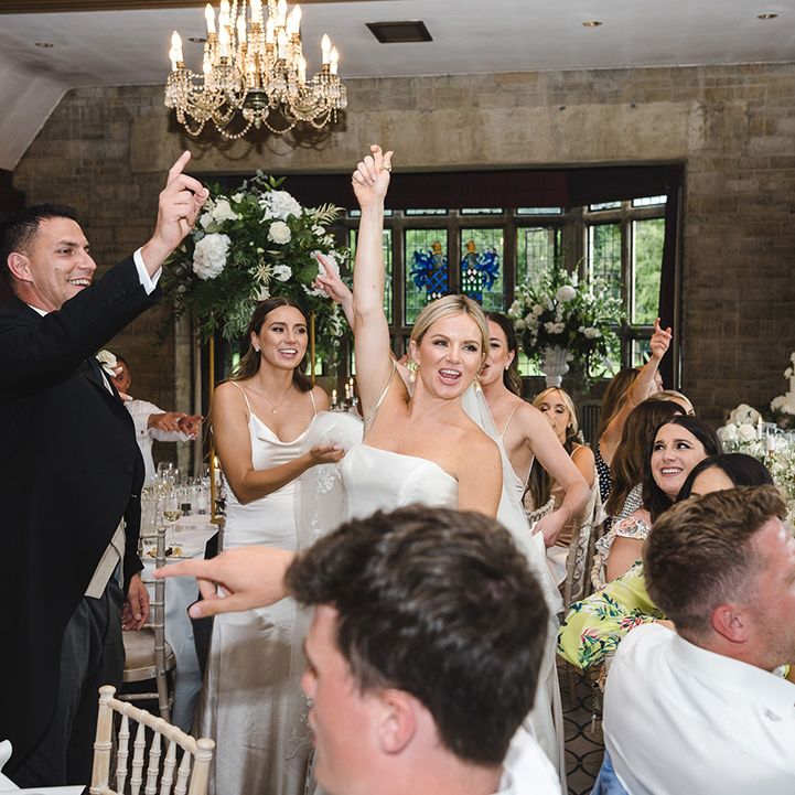 The wedding guests celebrate together for their wedding reception with the wedding band playing 