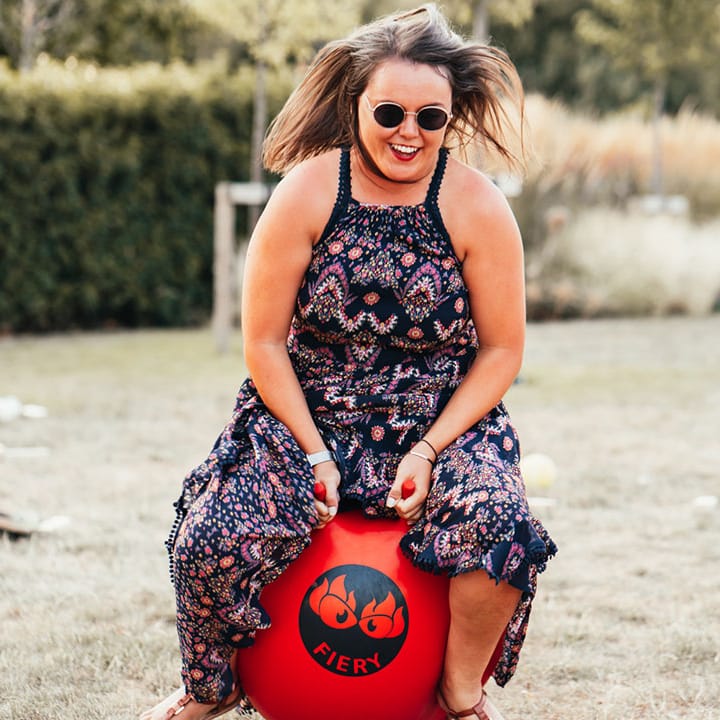 A wedding guest enjoys the wedding entertainment by making use of the space hoppers at Rackleys Chiltern Hills barn wedding venue 