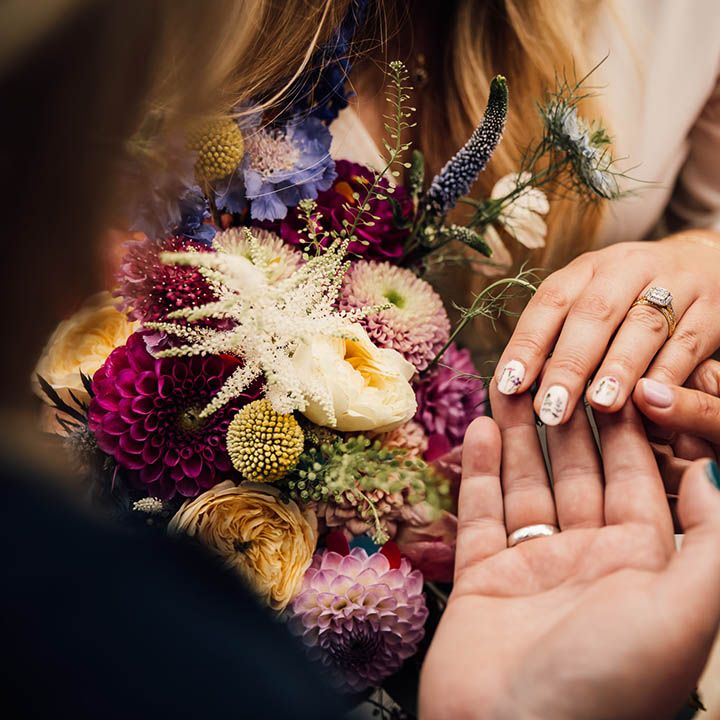 Bride with white wedding nails decorated with mini wildflowers to match the botanical seasonal wedding theme 