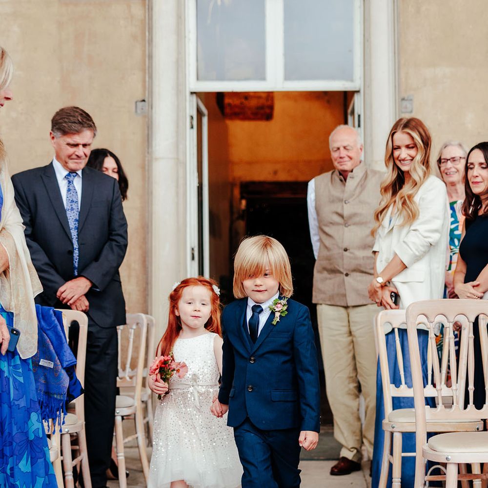 The flower girl and page boy walk down the aisle 