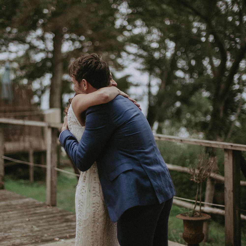 Groom embraces bride outdoors during first look moment