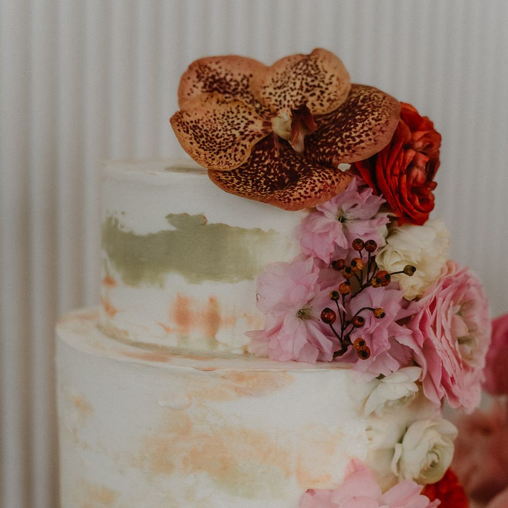Two tier brush effect wedding cake with pink flower decorations