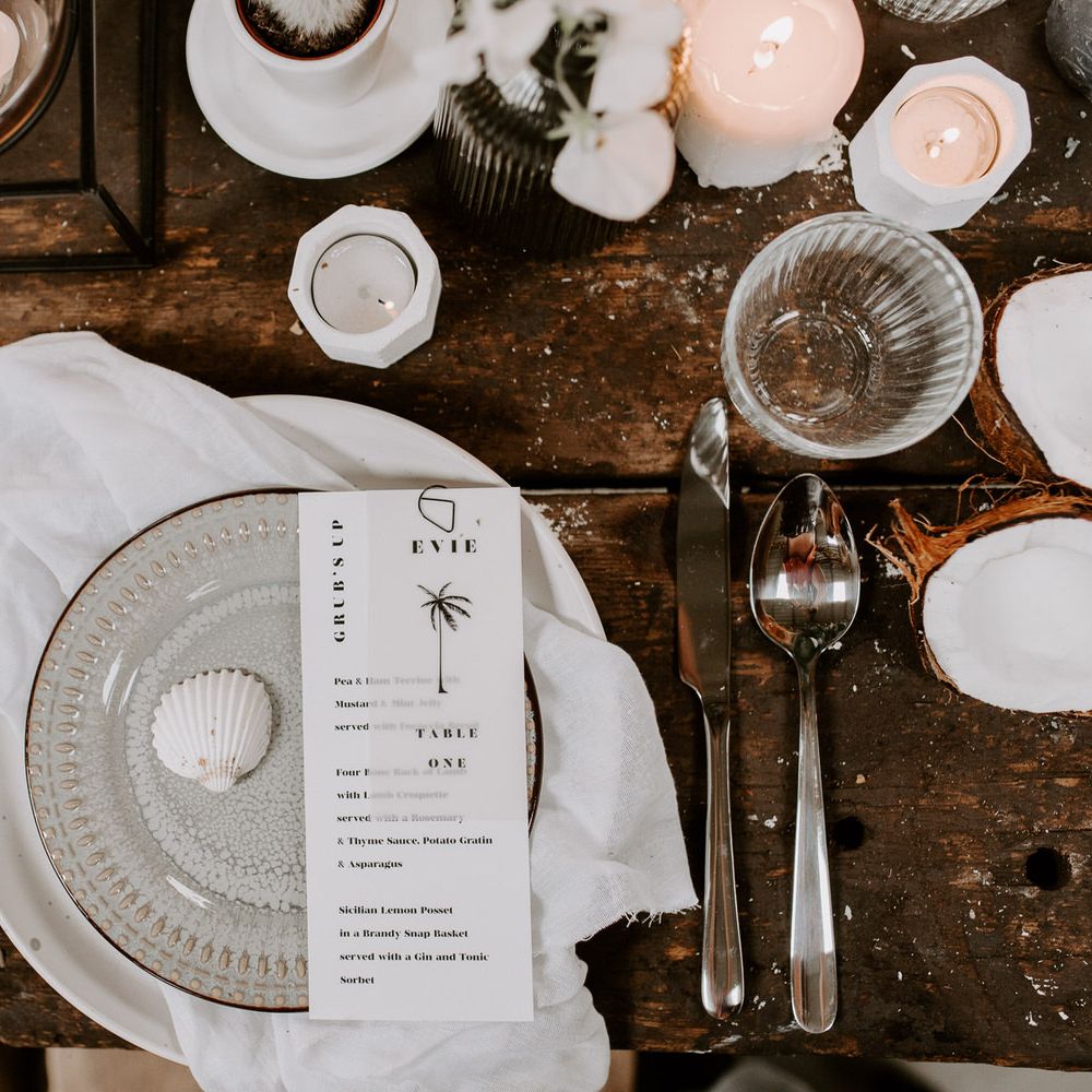 Black and white tropical wedding tablescape with neutral ceramics