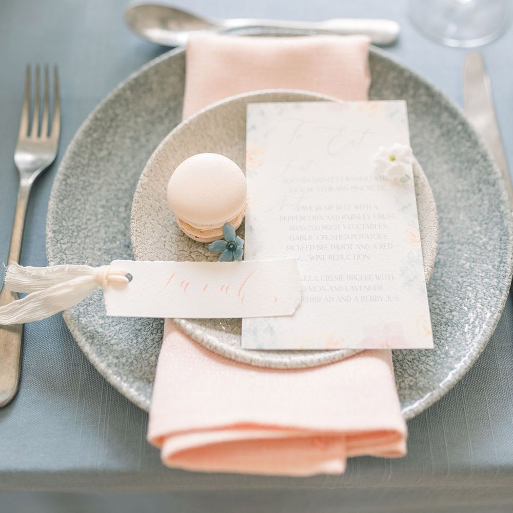 Pastel pink and peach wedding place setting with macaroon favour and floral design menu card