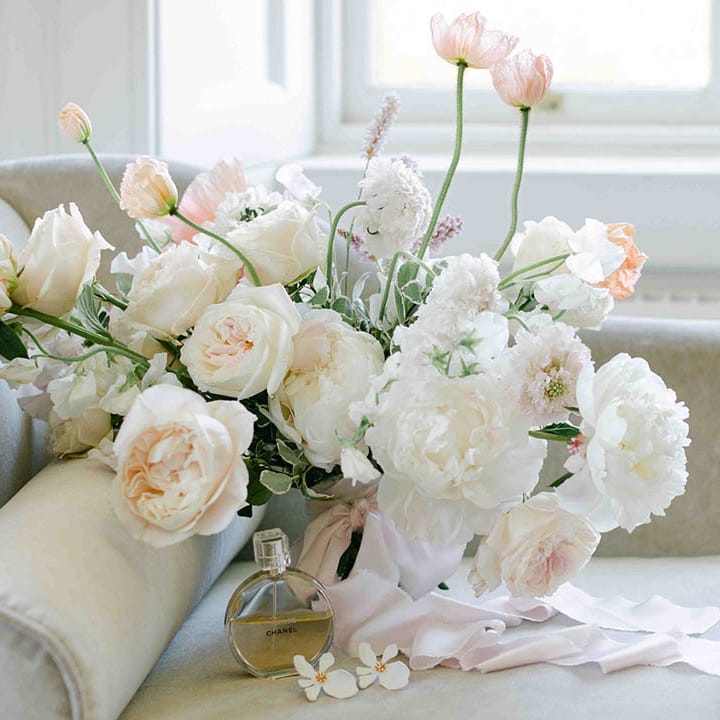 Bridal bouquet with white roses and peonies and the bridal shoes and perfume accessories 