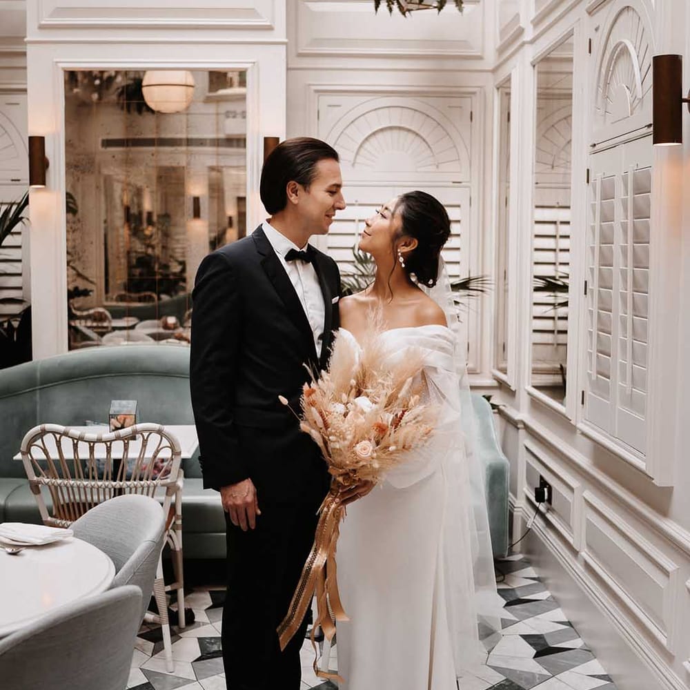 Bride and Groom in gorgeous modern aesthetic surroundings holding dried flower bouquet 