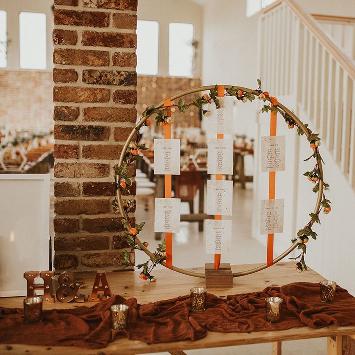 Hoop wedding table seating plan with orange ribbon