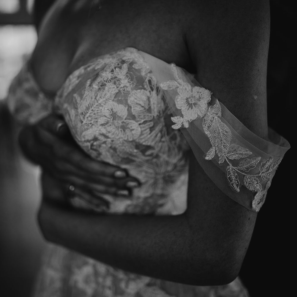 Bride slips into her off the shoulder lace wedding dress from Martina Liana