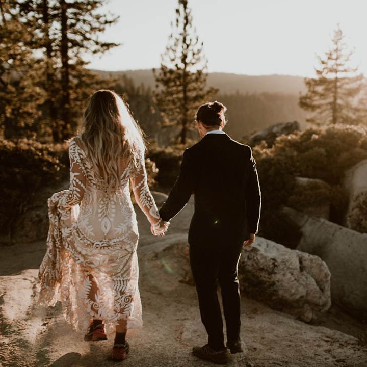 Bride & groom walk hand in hand with one another