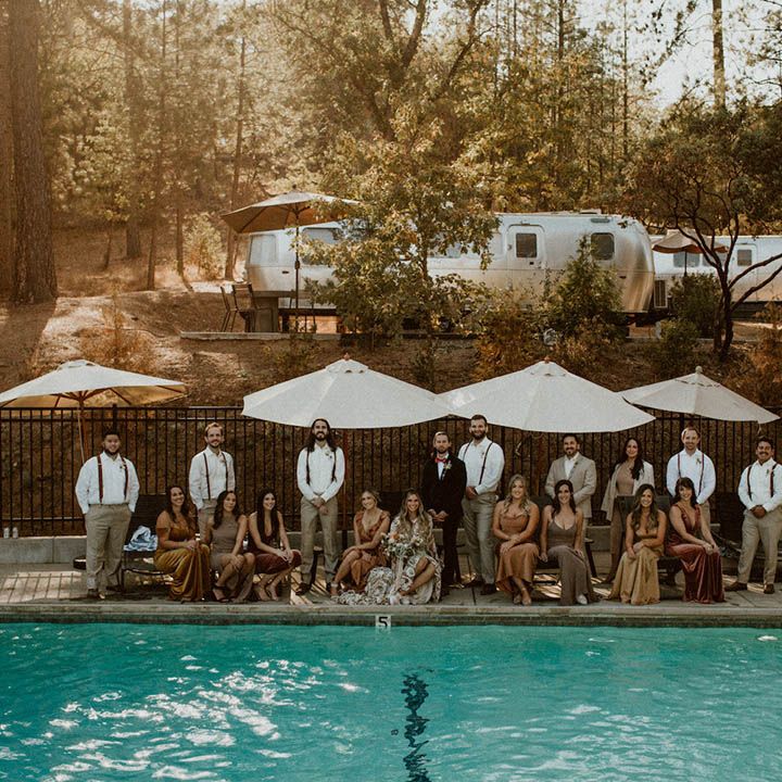 Wedding guests gather around poolside 