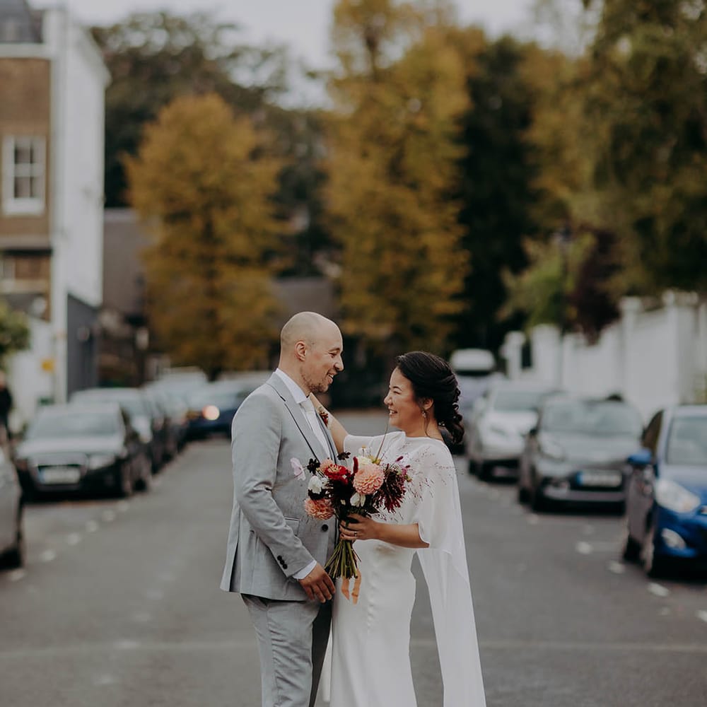 Bride & groom walk down the street with one another after ceremony 