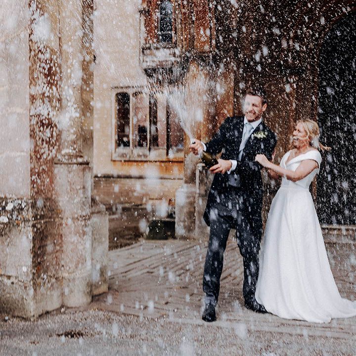 Bride and groom wedding photograph popping champagne 