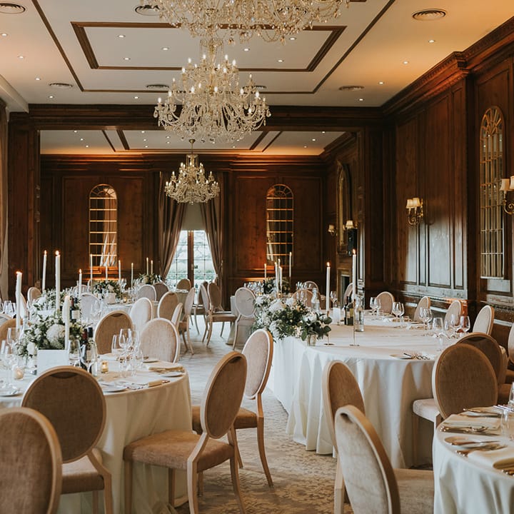 Wedding reception room at Hedsor House for classic wedding with chandeliers and circular wedding tables 