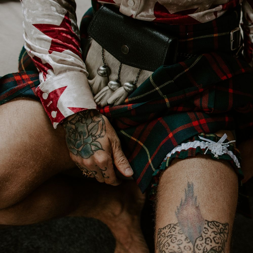 Groom wears tartan kilt and garter on the morning of his wedding day