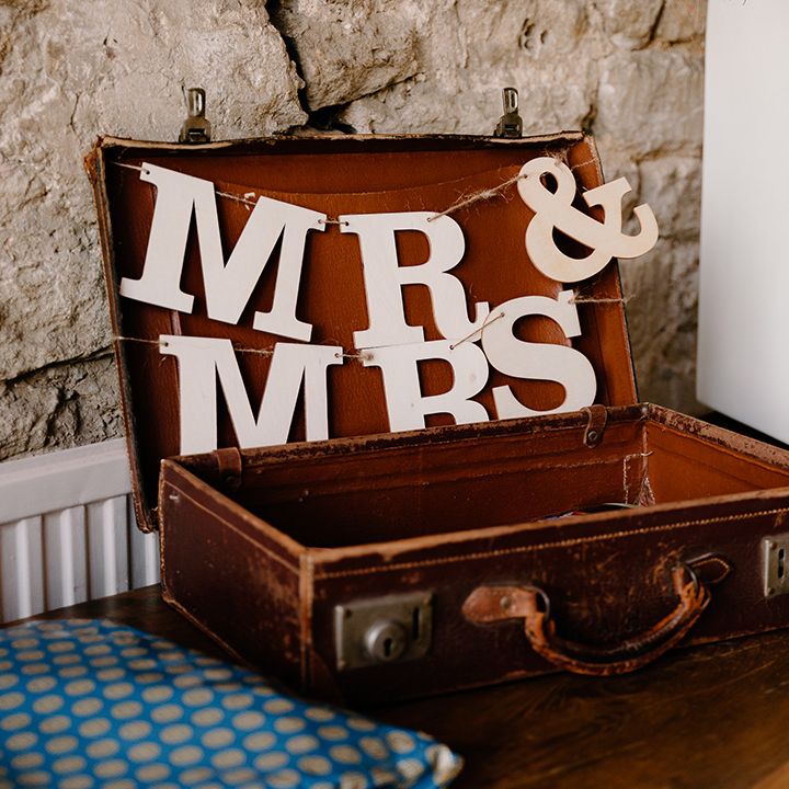 An open brown leather vintage suitcase with mr & mrs decor for cards