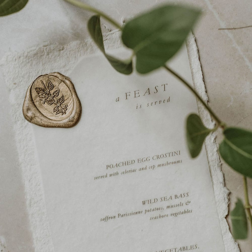 Wedding menu on the day stationery with gold font and wax seal design 