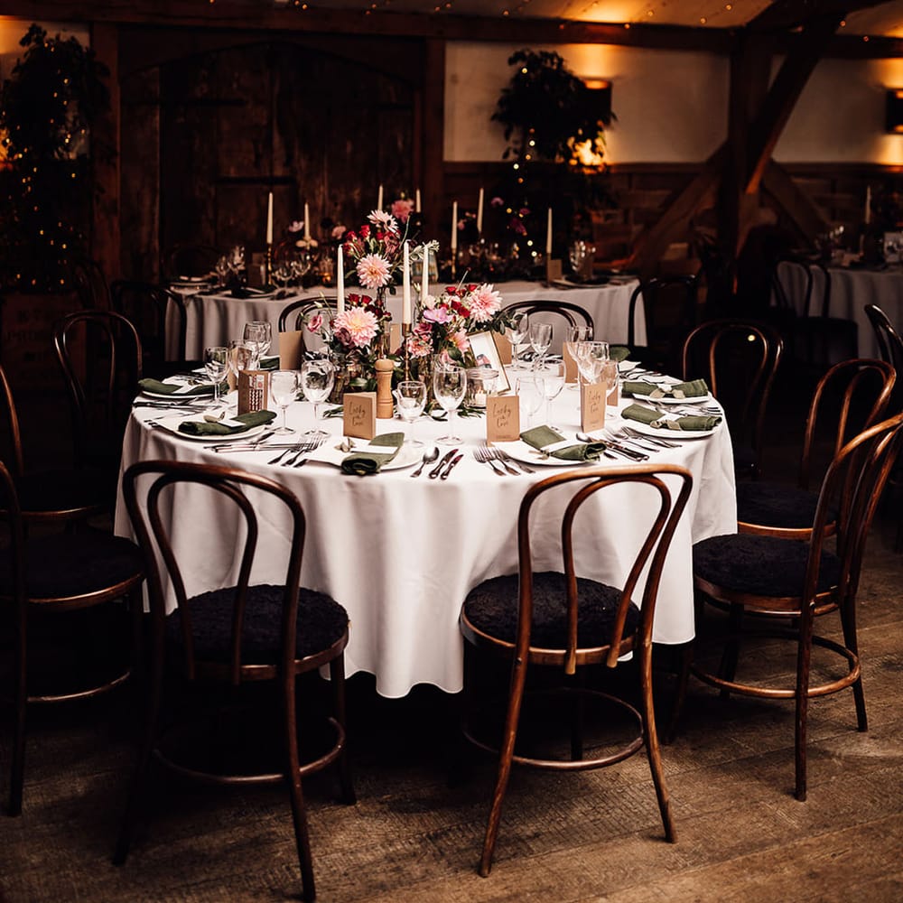 Wedding tablescape at Cripps Barn with pink and purple wedding flowers and green napkins 
