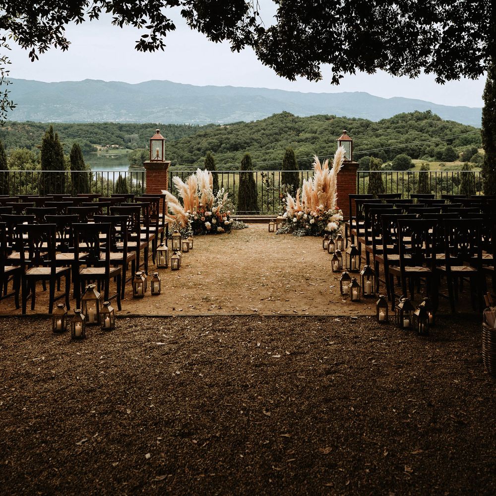 Italian wedding ceremony is Tuscany with pampas grass decor and views of the Tuscan hills