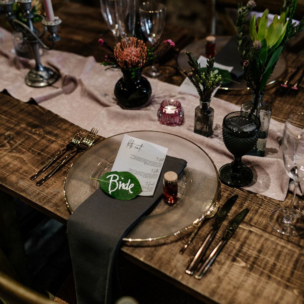 Place setting with glass charger plate and leaf name place card.