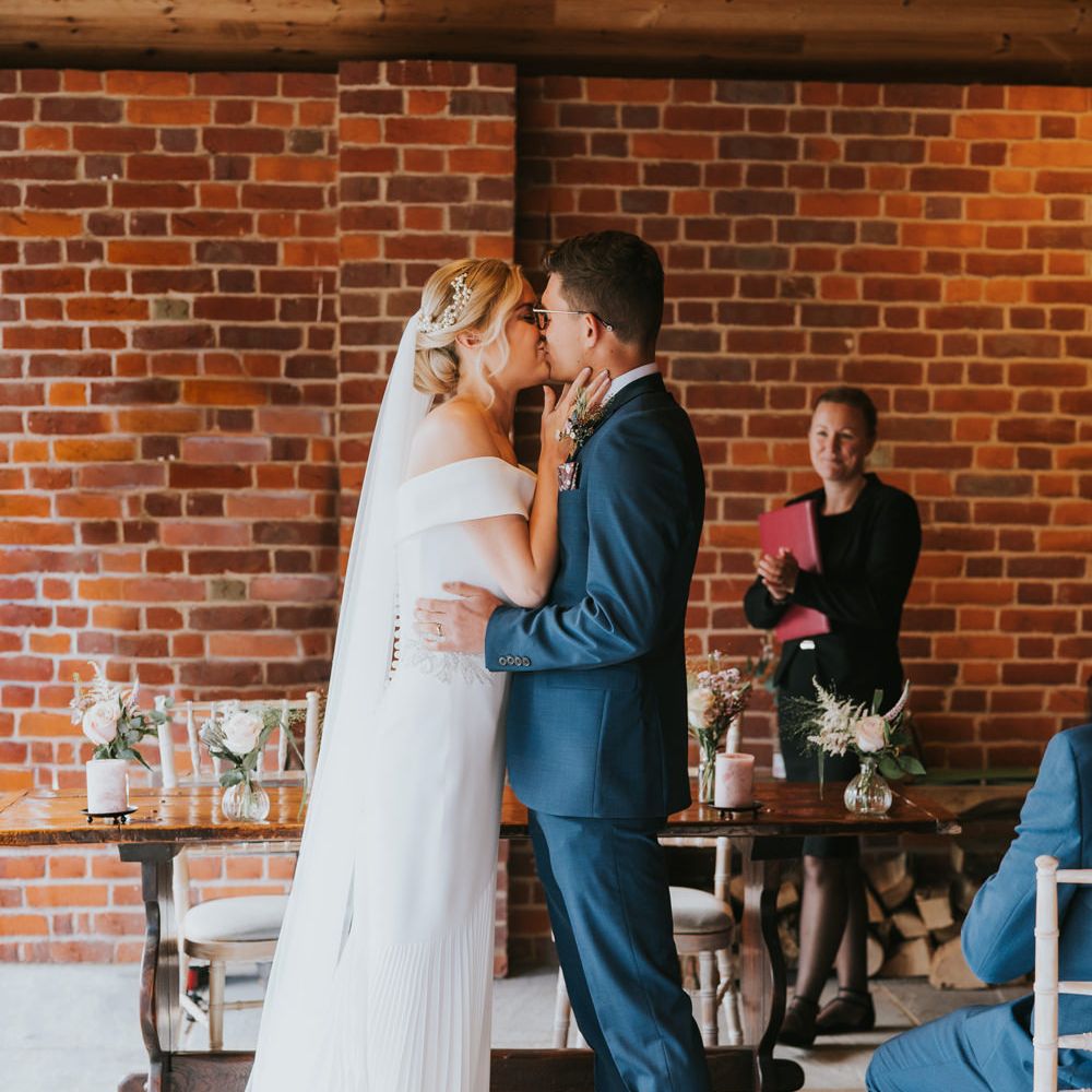 Bride & groom kiss during wedding ceremony