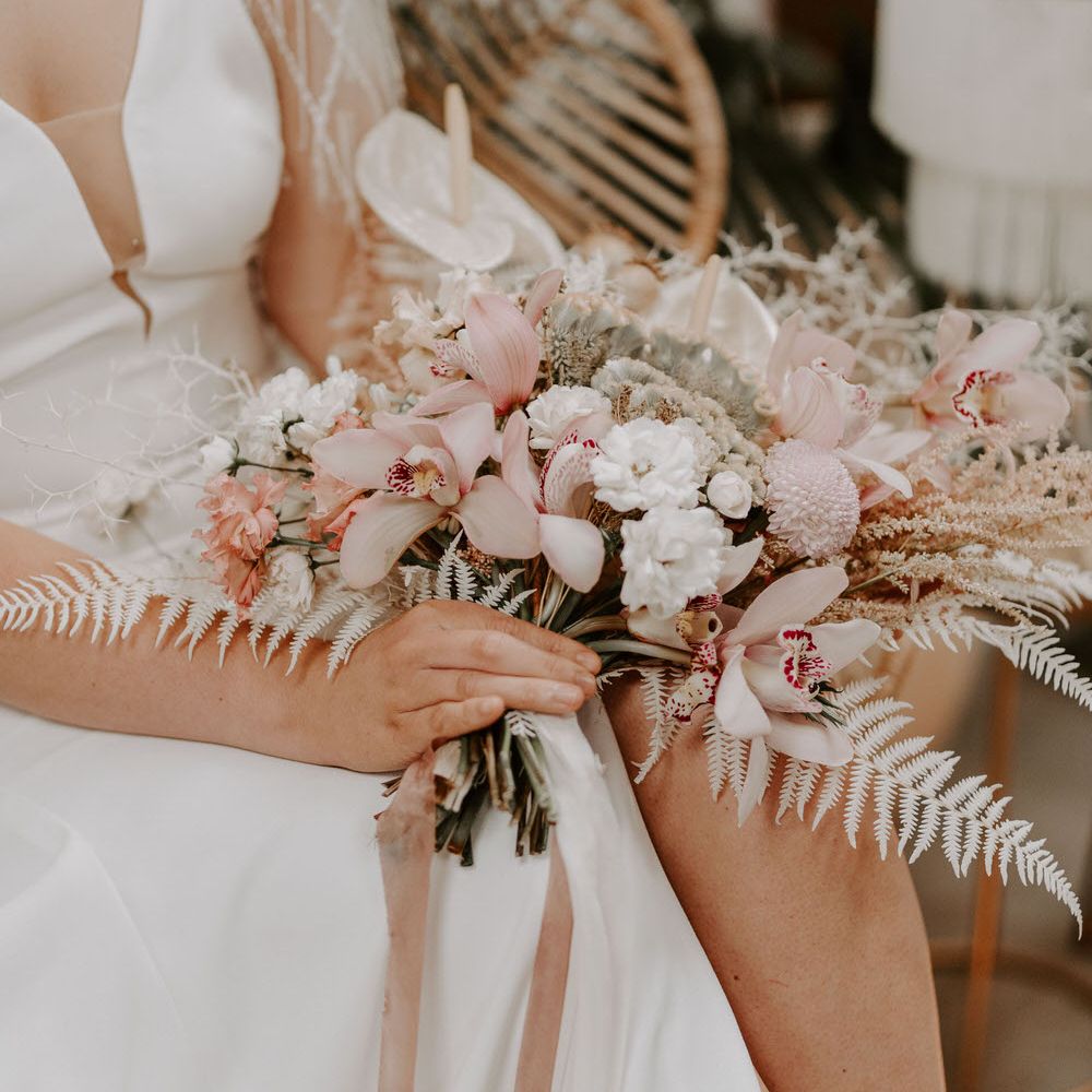 Tropical wedding bouquet with pink and white flowers including chrysanthemums, lilies, anthuriums and white ferns
