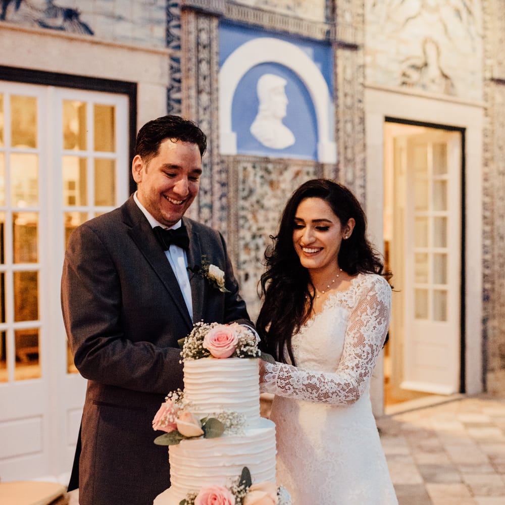 Bride & groom cut wedding cake as bride wears white bridal gown from Pronovias 
