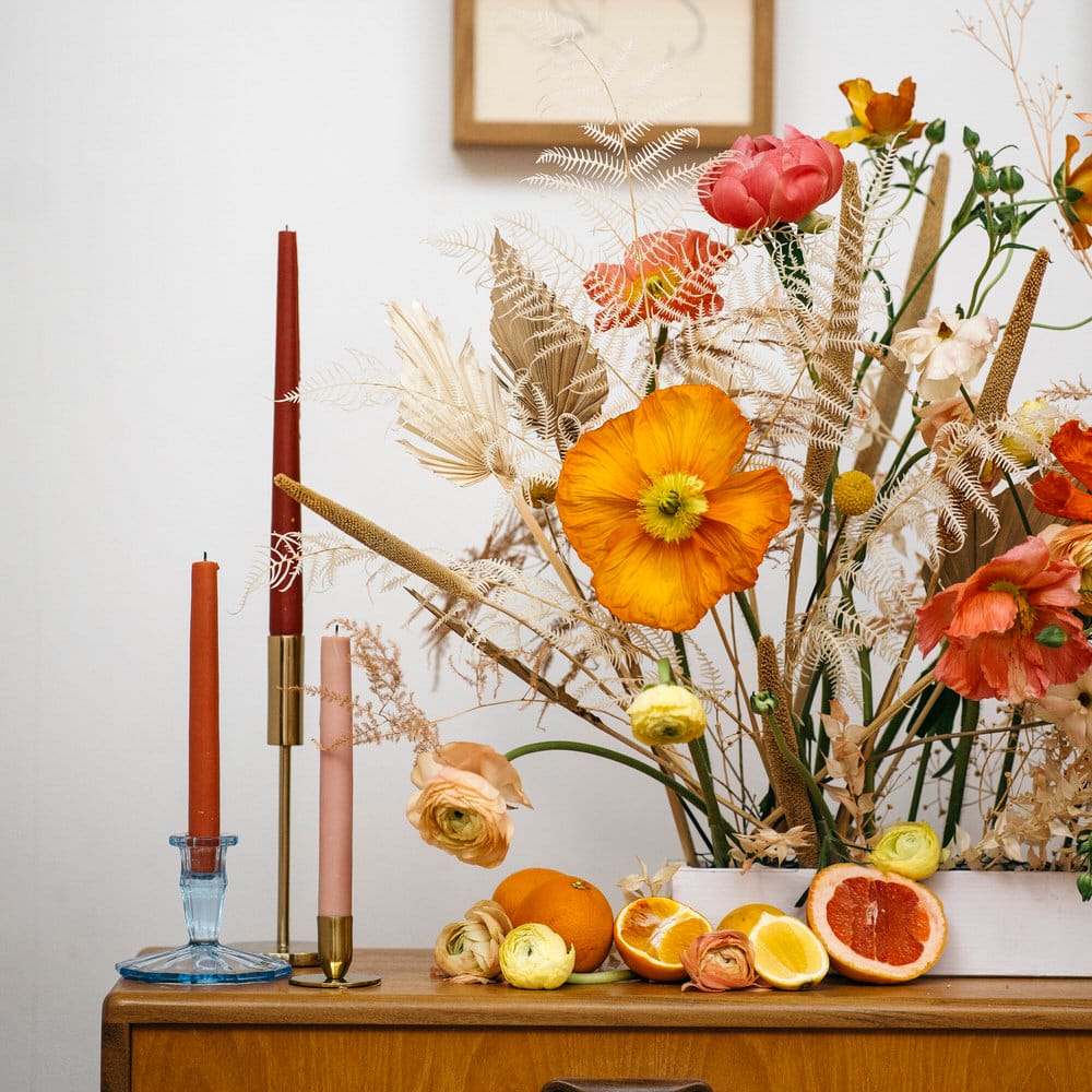 Autumnal colour tapered candles with orange, yellow and dried flower display