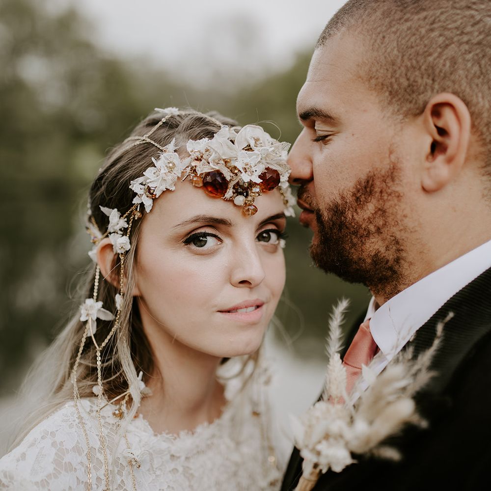 Beautiful boho bride with black eyeliner and beige lipstick wearing an intricate headdress 