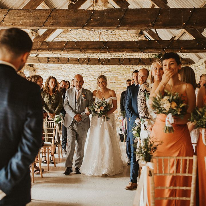 Bride walks down the aisle at barn wedding venue