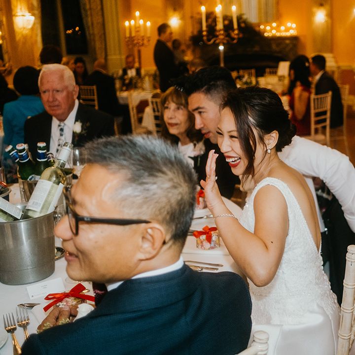 Bride laughs during wedding breakfast at Danesfield House 