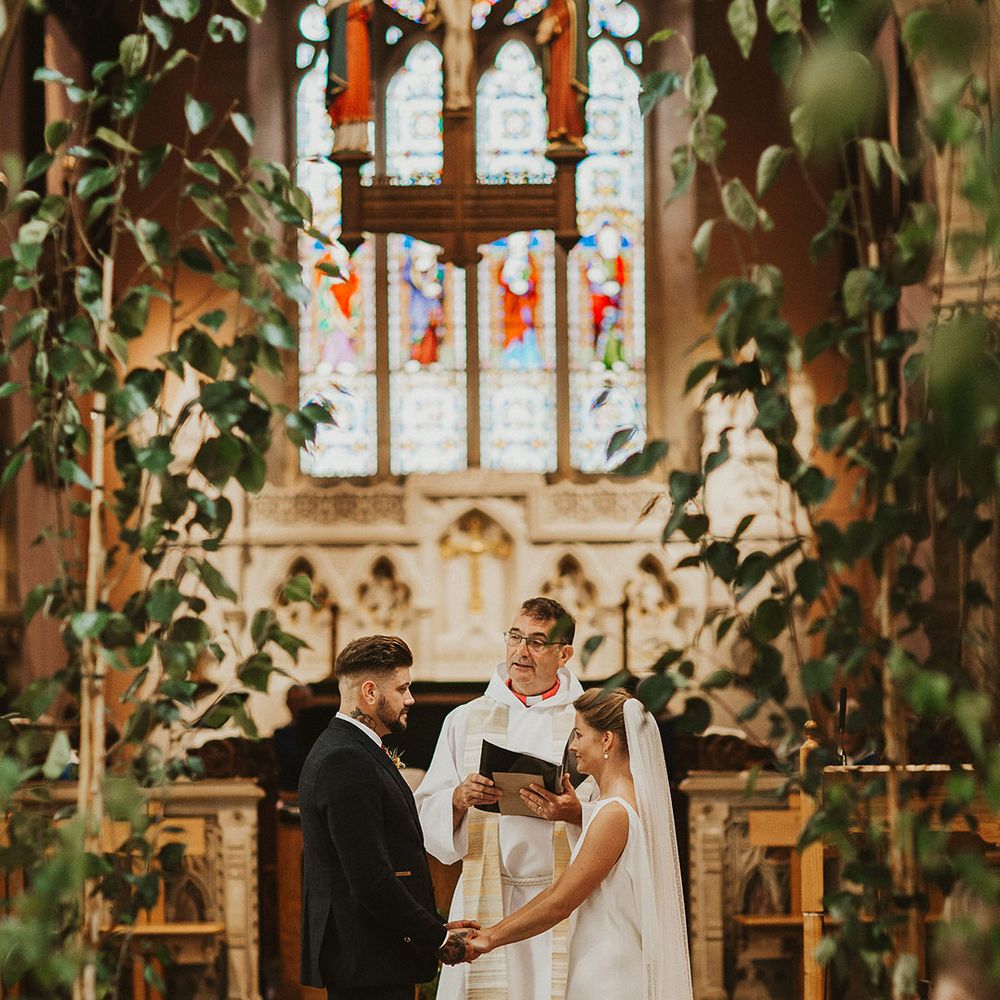 Bride and groom holding hands at the altar of their church wedding ceremony 