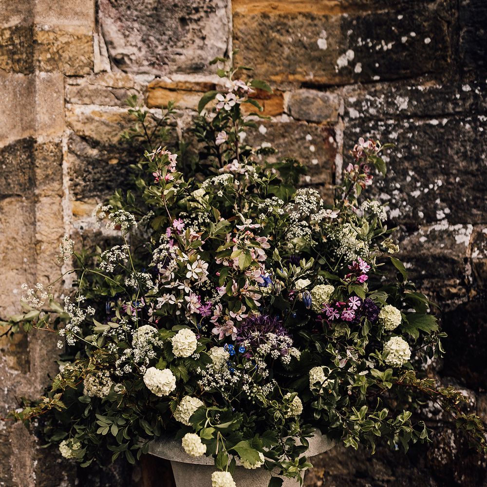 Purple, blue and white wedding flowers decorating the entrance to the church wedding including hydrangeas