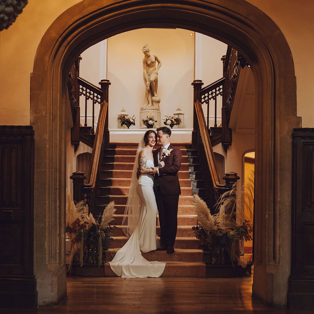 Bride & groom stand in the doorway at St Audries Park before wedding reception 