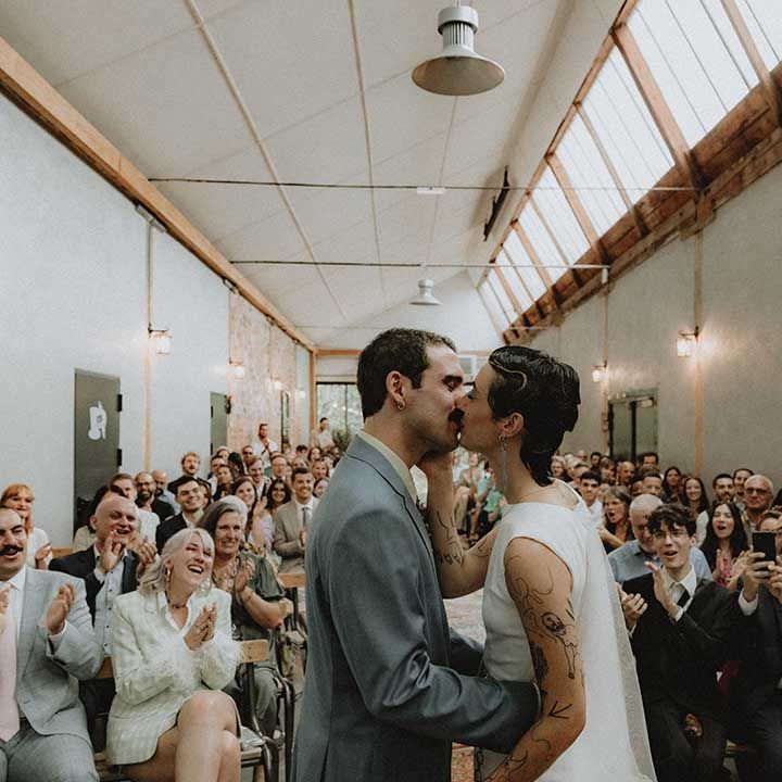 Lisa & Gabriel kiss after non denominational wedding ceremony with industrial vibe 