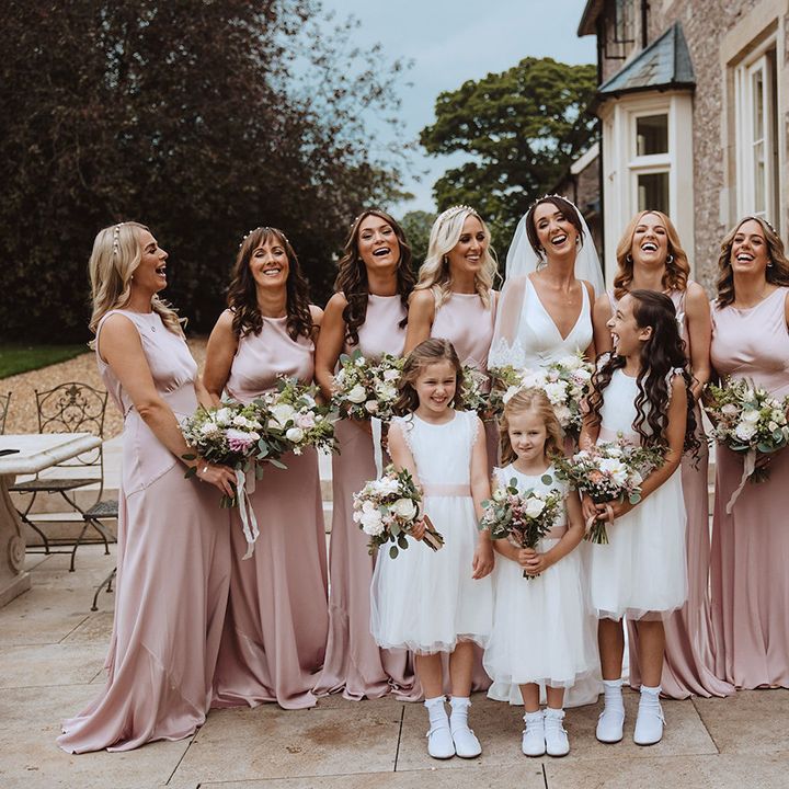 Blush pink theme wedding with bridesmaids in pink bridesmaid dresses with flower girls in white dresses