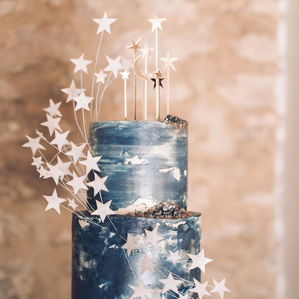 Two tier dark blue frosted wedding cake with 3D white stars for midnight blue wedding theme 