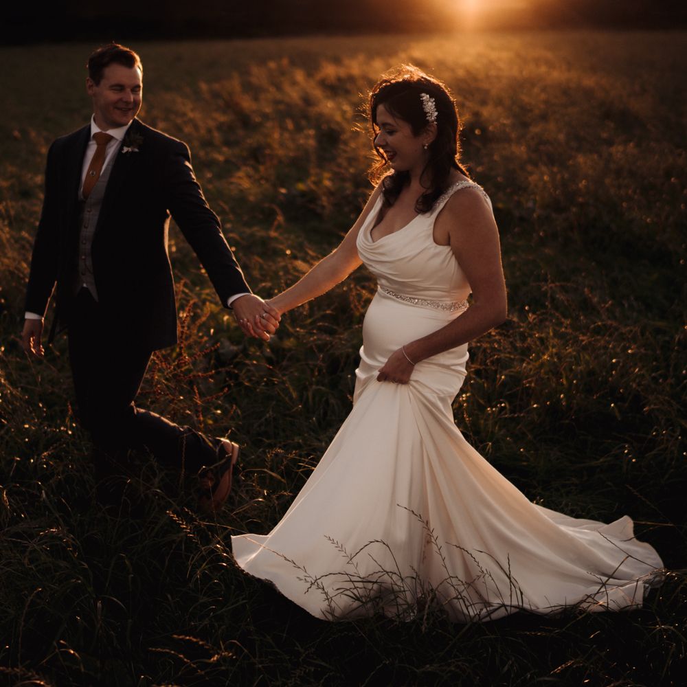 Bride & groom walk through the countryside in golden hour photoshoot