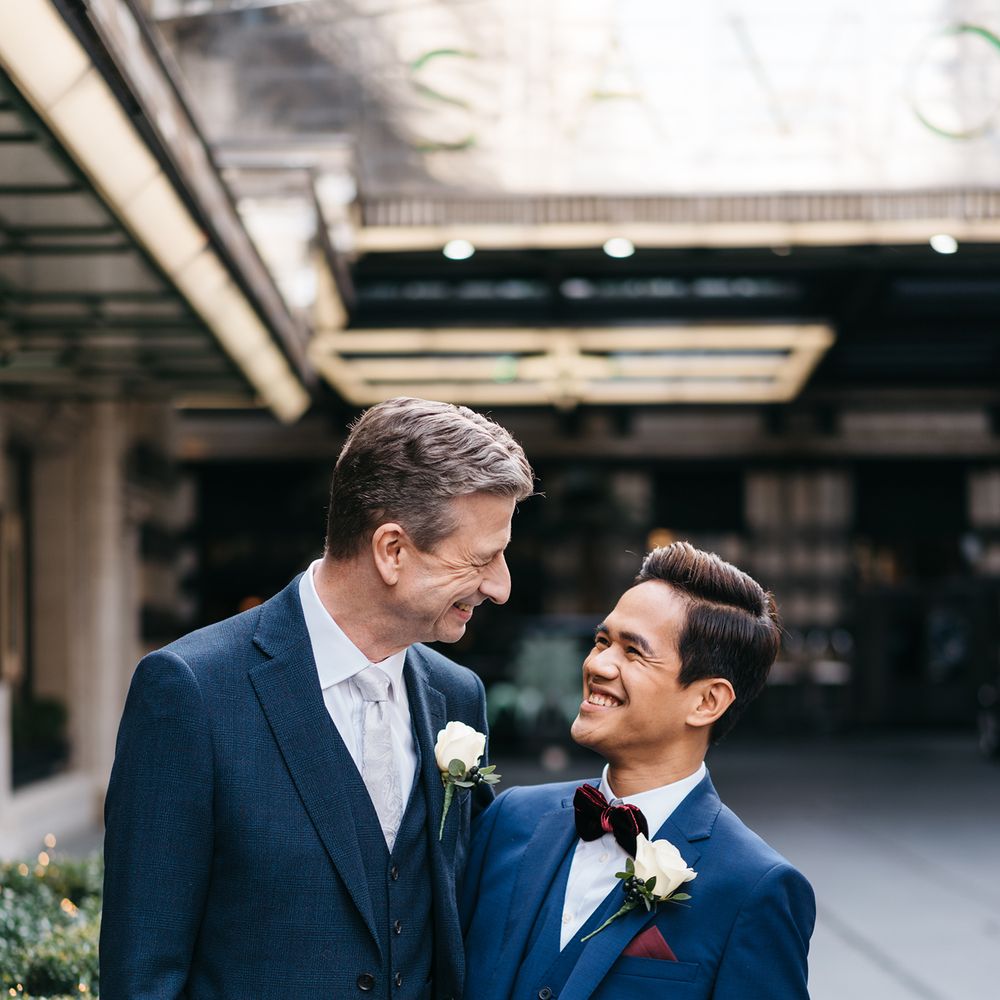 Grooms look at one another lovingly before wedding ceremony
