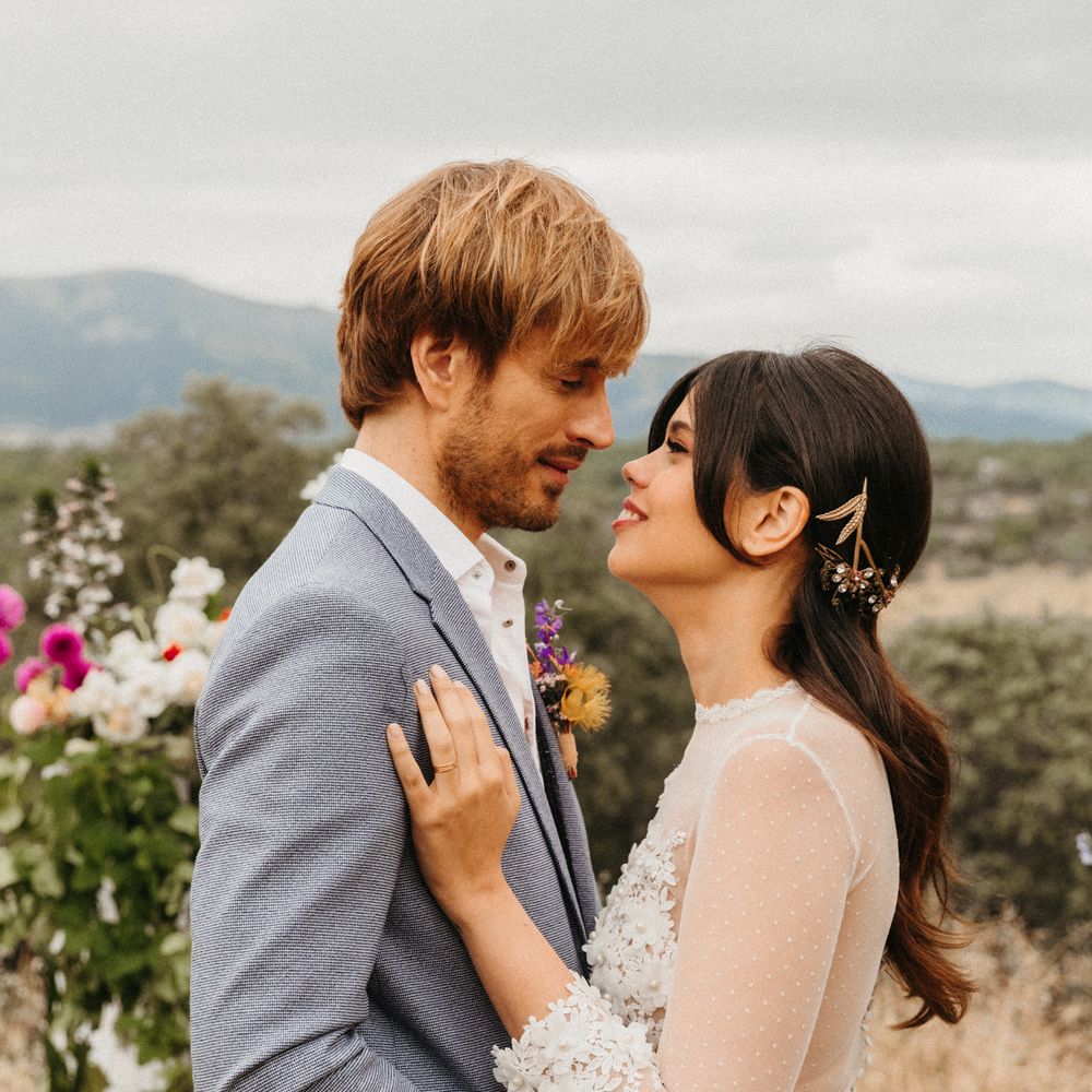Bride & groom look lovingly at one another with mountains in the background
