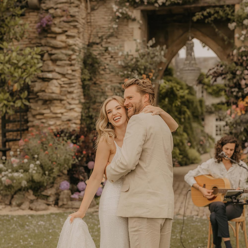 Groom in beige suit dancing with his bride in a Made With Love dress at Euridge Manor 